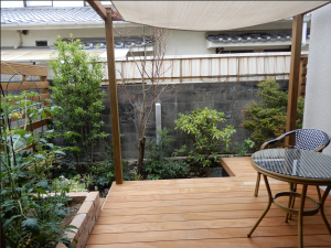 キッチン側の窓よりの風景 古くからある隣家のブロック塀を出来るだけ目立たなくするように植栽を配置。 気軽に採取できる家庭菜園の花壇は窓を出た場所に設置。